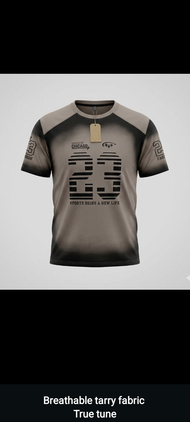 A short-sleeve athletic t-shirt with a gray and black gradient design, featuring a large number 23 on the front and a gold neck label, shown against a light gray background.